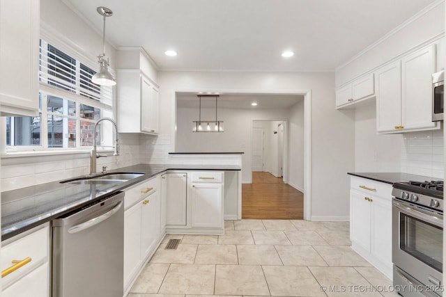 kitchen with white cabinetry, sink, hanging light fixtures, and appliances with stainless steel finishes