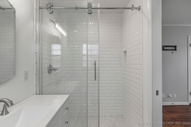 bathroom with ornamental molding, vanity, an enclosed shower, and wood-type flooring