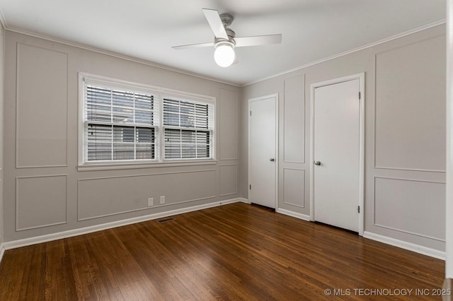 unfurnished bedroom featuring crown molding, dark wood-type flooring, and ceiling fan