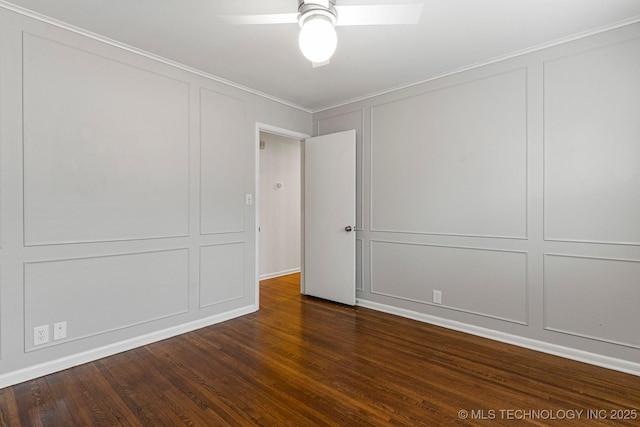 spare room featuring crown molding, dark wood-type flooring, and ceiling fan