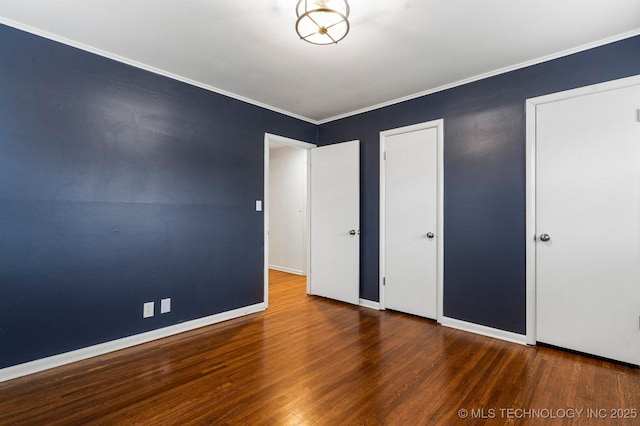 unfurnished bedroom featuring wood-type flooring, ornamental molding, and a closet