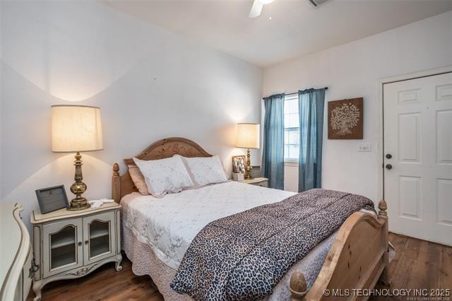 bedroom with dark wood-type flooring and ceiling fan