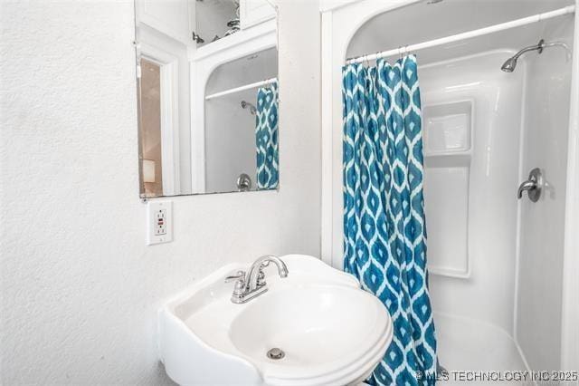 bathroom with curtained shower and sink