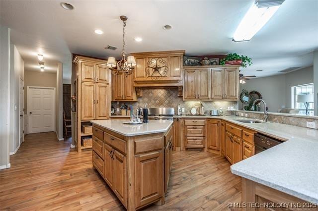 kitchen featuring pendant lighting, tasteful backsplash, sink, light hardwood / wood-style floors, and kitchen peninsula