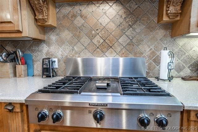 room details featuring tasteful backsplash and stainless steel gas cooktop