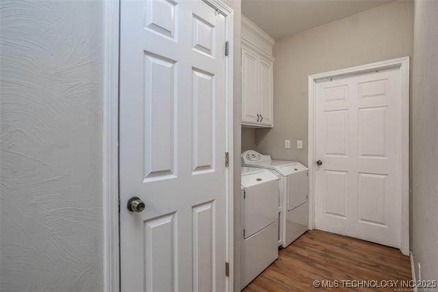 laundry area with cabinets, dark hardwood / wood-style flooring, and independent washer and dryer