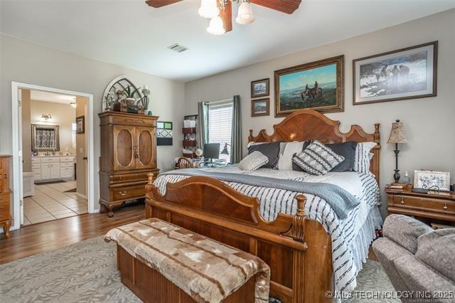 bedroom featuring ceiling fan, connected bathroom, and light hardwood / wood-style floors