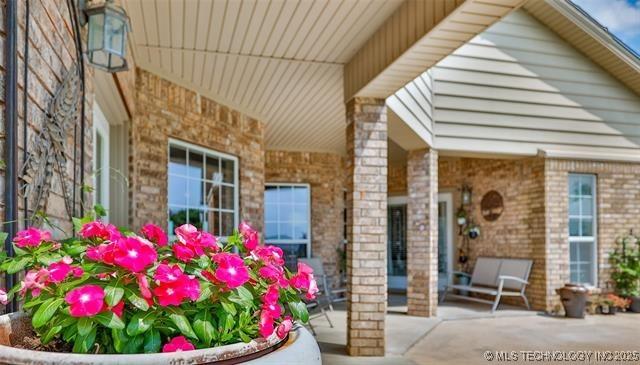 view of exterior entry with a patio