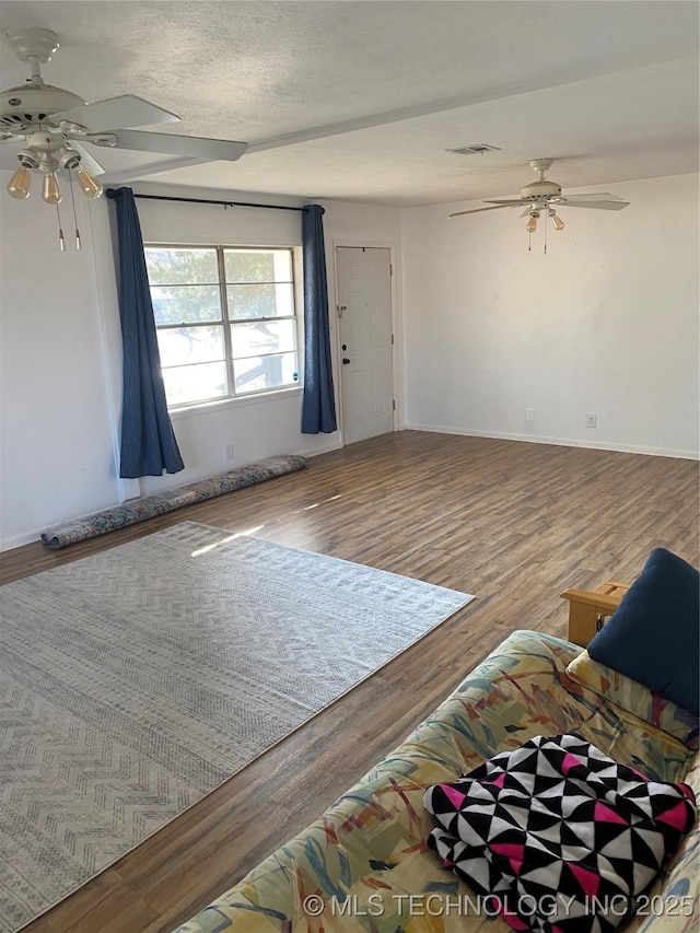 unfurnished living room with hardwood / wood-style flooring, ceiling fan, and a textured ceiling