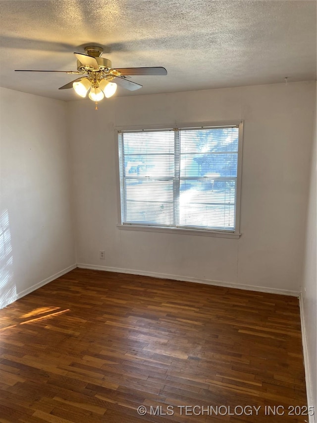 empty room featuring a healthy amount of sunlight, dark hardwood / wood-style flooring, and a textured ceiling