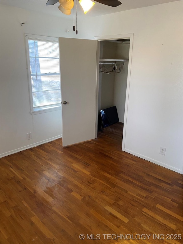 unfurnished bedroom with dark wood-type flooring, ceiling fan, and a closet