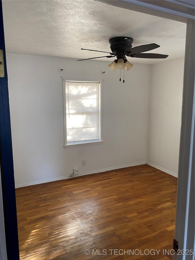 spare room with ceiling fan, dark wood-type flooring, and a textured ceiling