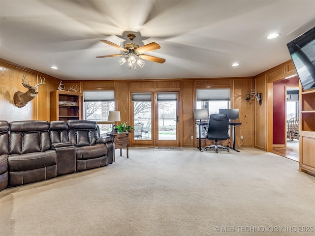 living room featuring crown molding, light carpet, and wood walls