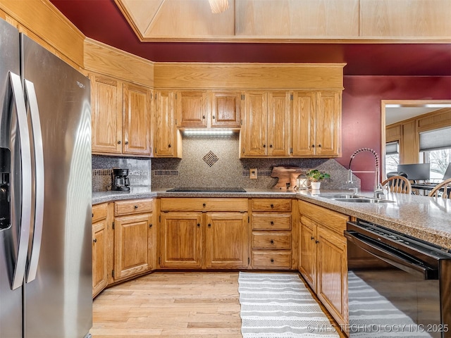 kitchen with sink, decorative backsplash, light hardwood / wood-style floors, and black appliances