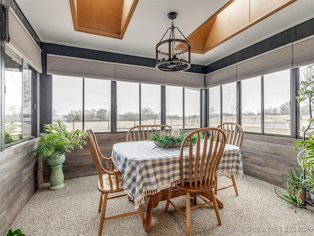 sunroom / solarium featuring an inviting chandelier