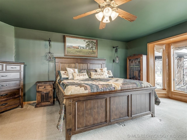 bedroom with light colored carpet and a ceiling fan