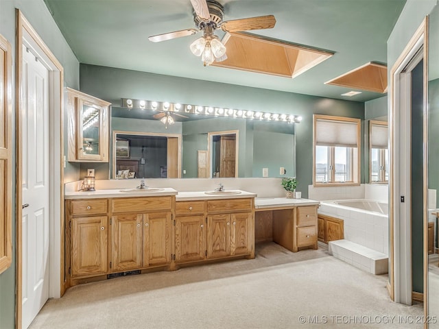 bathroom with vanity, a relaxing tiled tub, and ceiling fan