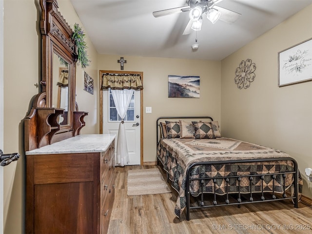 bedroom featuring a ceiling fan, light wood-style flooring, and baseboards