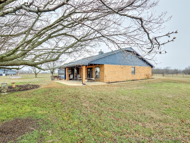 back of property with a patio area and a lawn