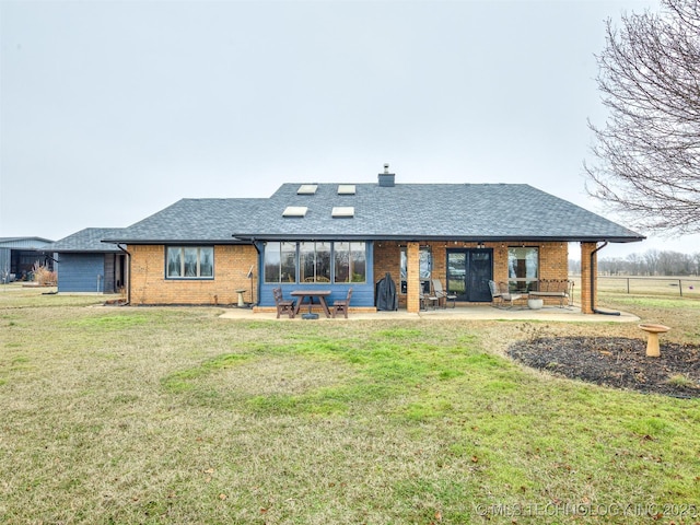 rear view of property featuring a patio and a lawn