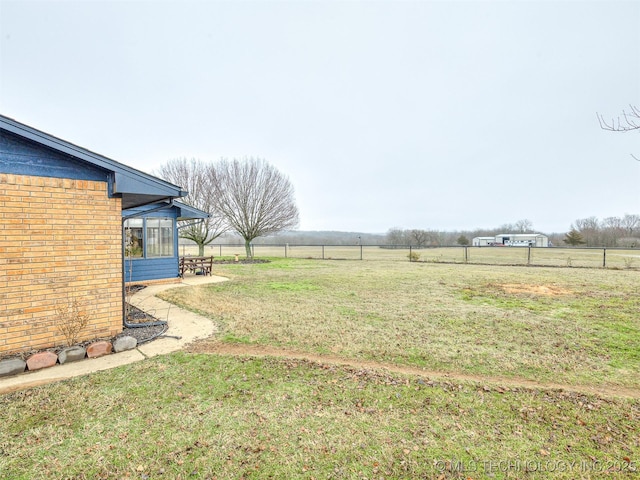 view of yard featuring a rural view and a sunroom