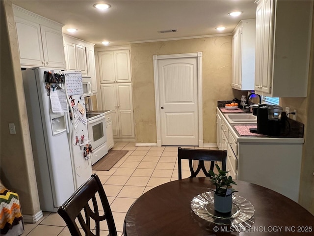 kitchen featuring white cabinetry, white appliances, sink, and light tile patterned floors