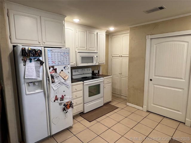 kitchen with light tile patterned floors, white appliances, and white cabinets