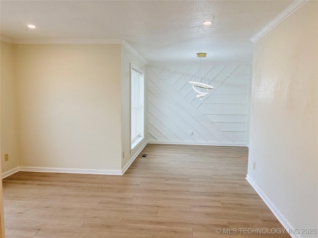 spare room featuring ornamental molding and light hardwood / wood-style flooring