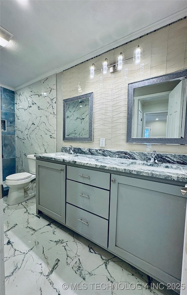 bathroom featuring vanity, toilet, and tile walls