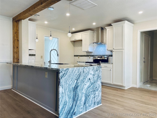 kitchen featuring white cabinetry, stainless steel electric range oven, sink, and wall chimney range hood