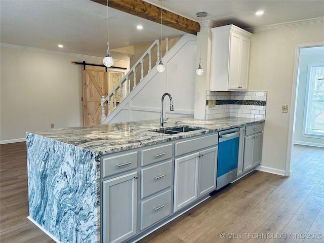 kitchen featuring sink, hanging light fixtures, dishwasher, and a barn door