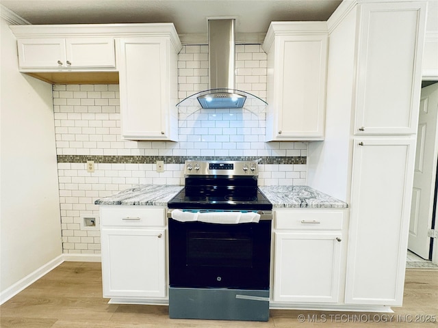 kitchen featuring white cabinets, stainless steel electric stove, light stone countertops, and wall chimney range hood