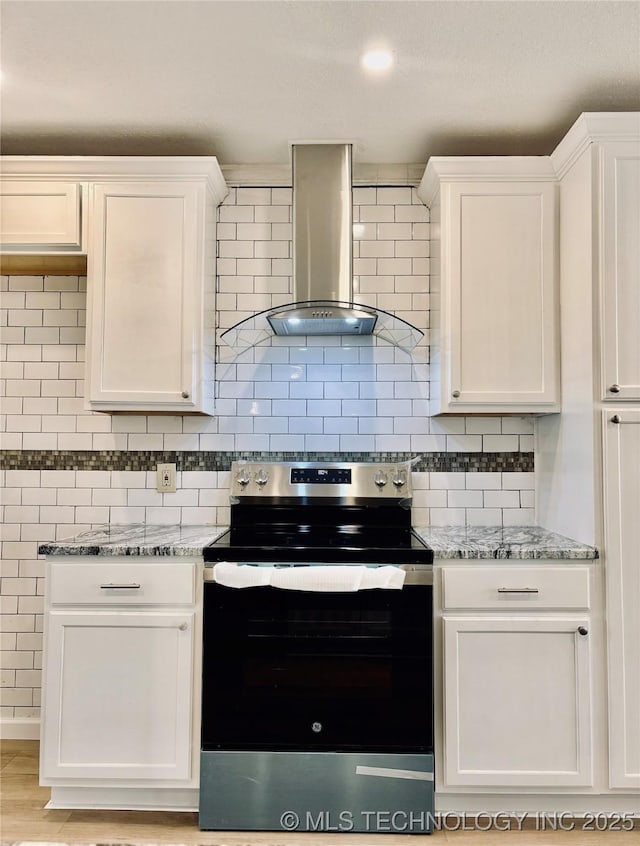 kitchen with white cabinetry, light stone counters, stainless steel range with electric cooktop, and wall chimney exhaust hood