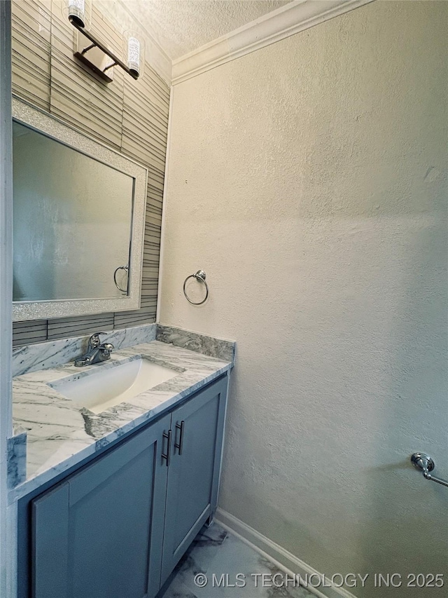 bathroom with crown molding, vanity, and a textured ceiling