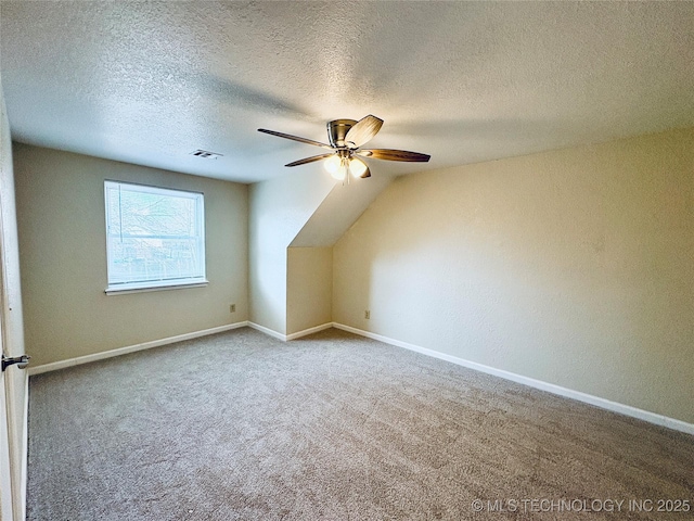 bonus room with a textured ceiling, ceiling fan, and carpet