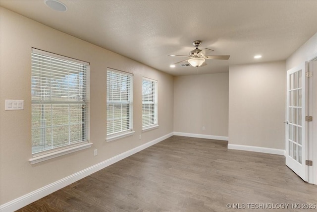 unfurnished room featuring ceiling fan, a textured ceiling, and light wood-type flooring