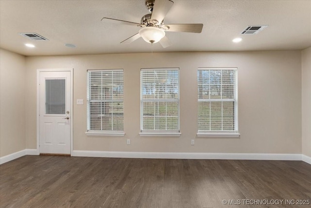 unfurnished room with ceiling fan, dark hardwood / wood-style floors, and a textured ceiling