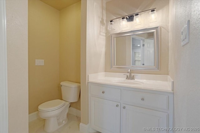 bathroom featuring toilet, vanity, tile patterned floors, and baseboards