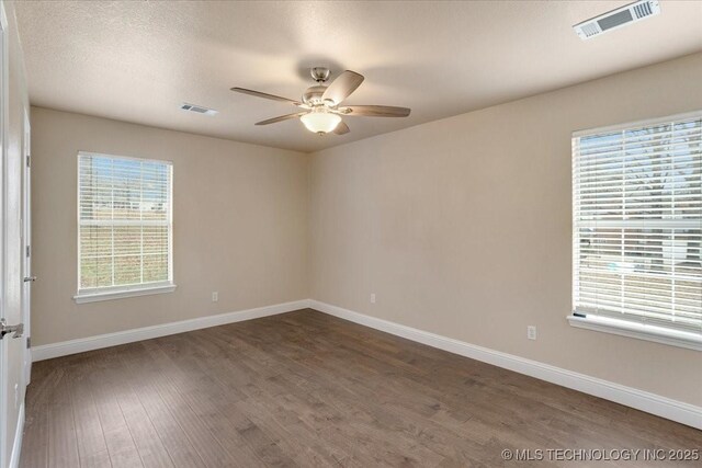 empty room featuring ceiling fan, a textured ceiling, and dark hardwood / wood-style flooring