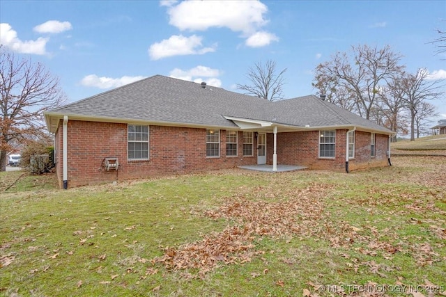 rear view of property with a yard and a patio area