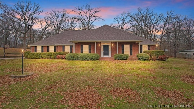 ranch-style home featuring a lawn