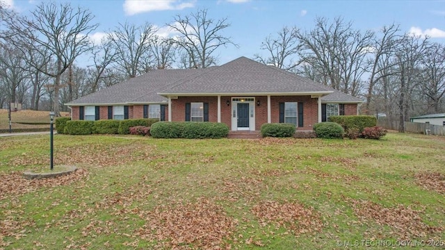 view of front of property with brick siding, fence, and a front yard
