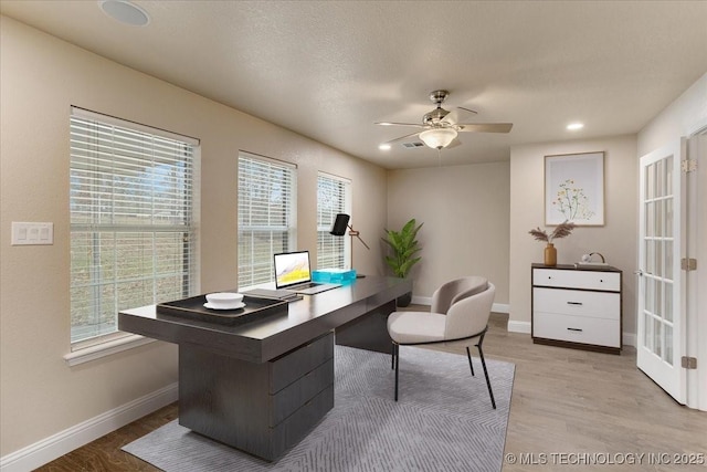 office featuring a healthy amount of sunlight, light hardwood / wood-style flooring, and a textured ceiling