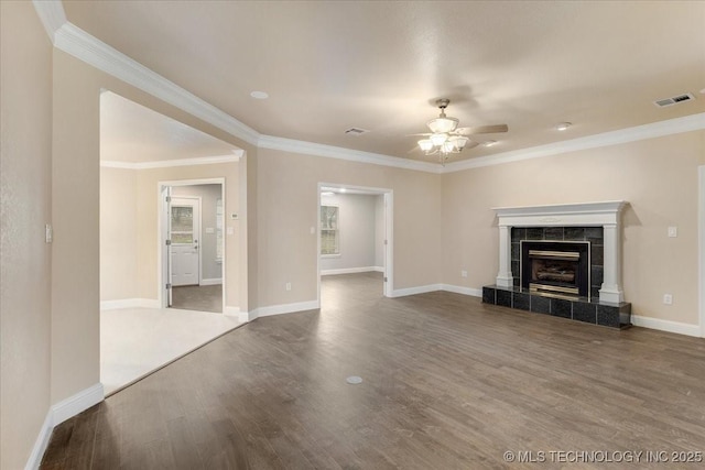 unfurnished living room with ceiling fan, ornamental molding, wood-type flooring, and a tile fireplace