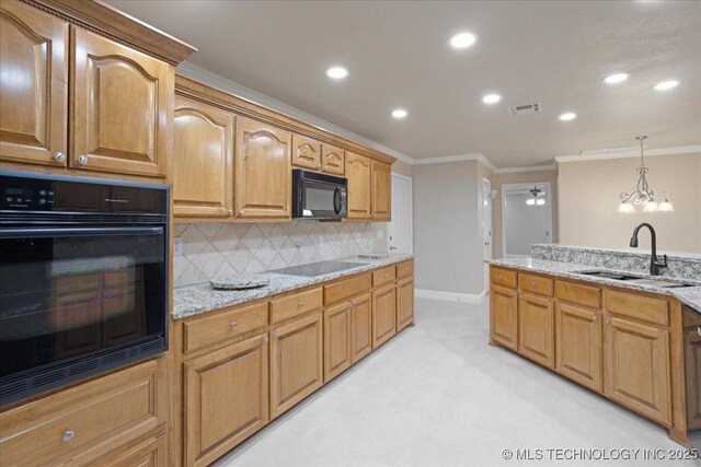 kitchen with crown molding, sink, light stone counters, and black appliances