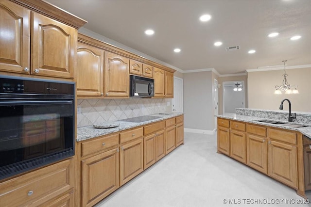 kitchen featuring backsplash, a sink, light stone counters, visible vents, and black appliances