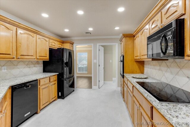 kitchen featuring tasteful backsplash, light stone countertops, crown molding, and black appliances