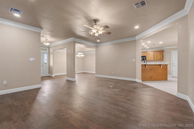 unfurnished living room featuring visible vents, ceiling fan with notable chandelier, and wood finished floors