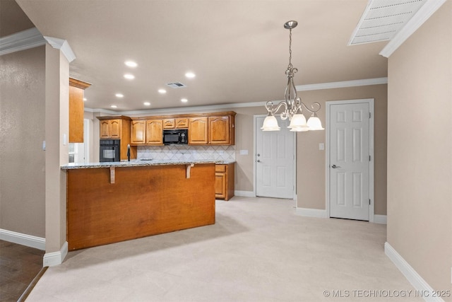 kitchen with brown cabinets, visible vents, black appliances, and a breakfast bar