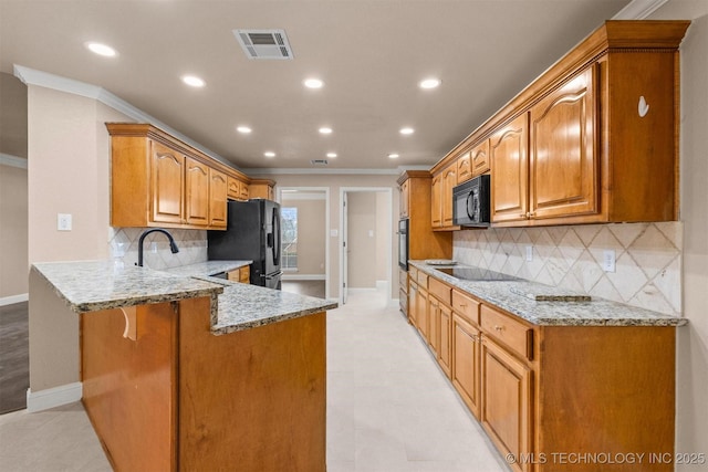 kitchen featuring light stone countertops, a peninsula, visible vents, black appliances, and ornamental molding